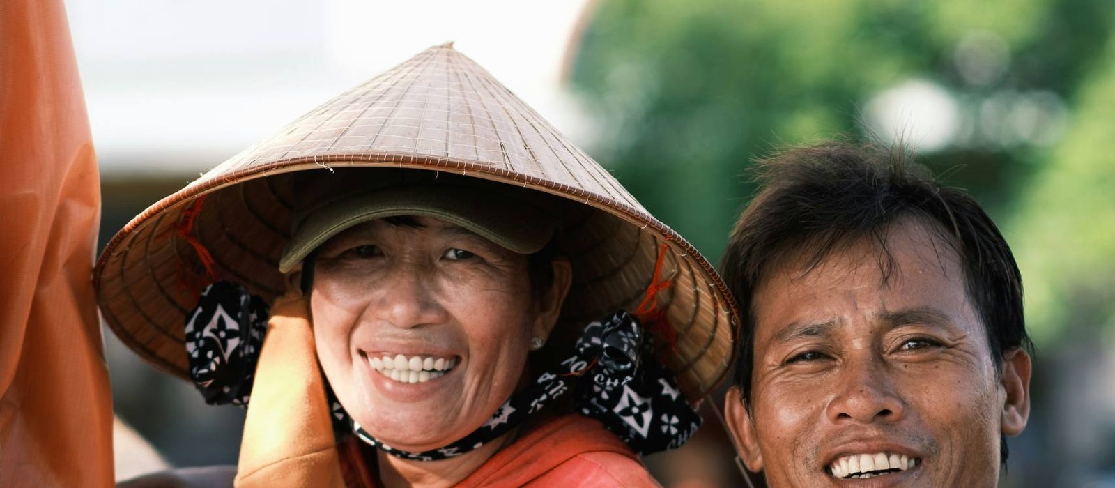 Two local people smiling together on a sunny street