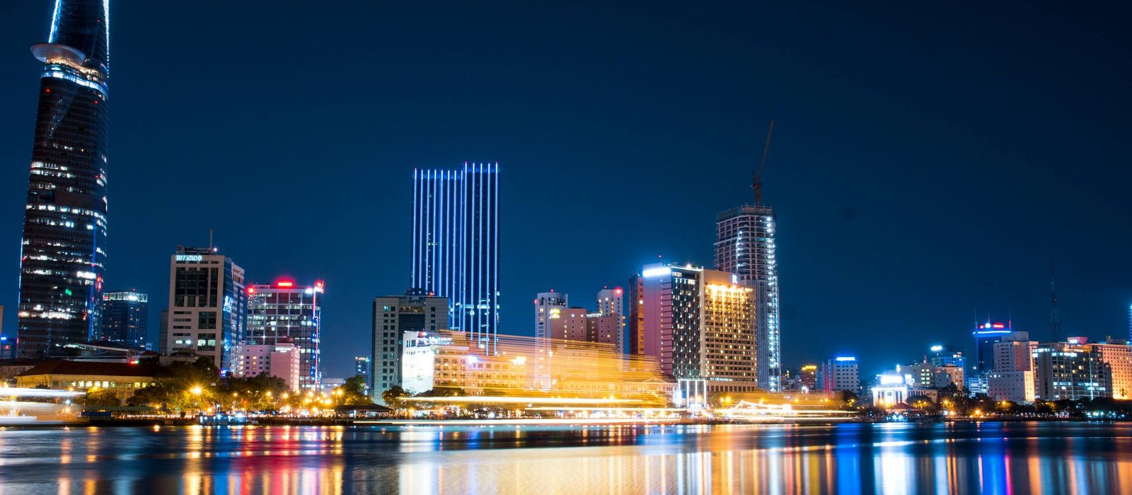 Ho Chi Minh City skyline lit up along the river at night