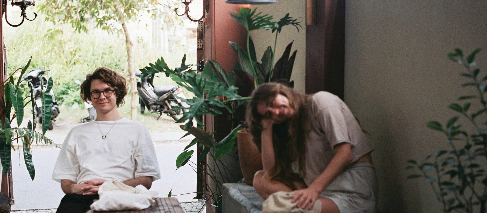 Two travellers relaxing at a plant-filled café