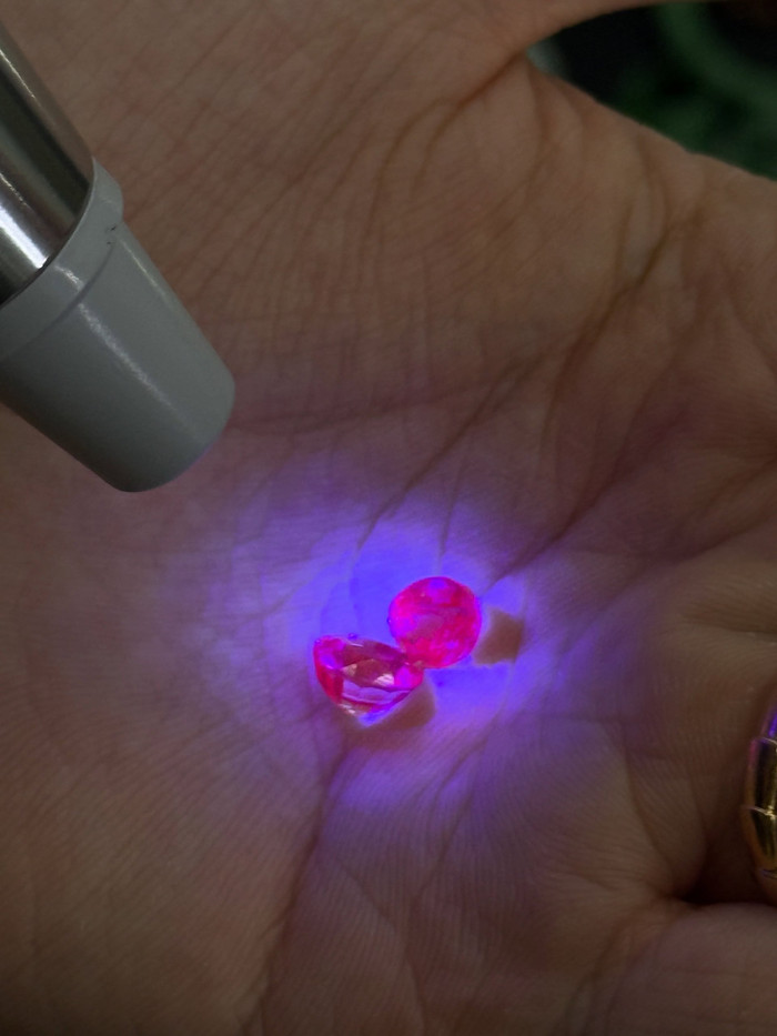 Gemstones glowing under an ultraviolet torch during an authenticity check